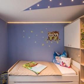 Modernes Kinderzimmer mit gemütlichem Bett, Eulen-Wanddeko und bunten Kissen.
